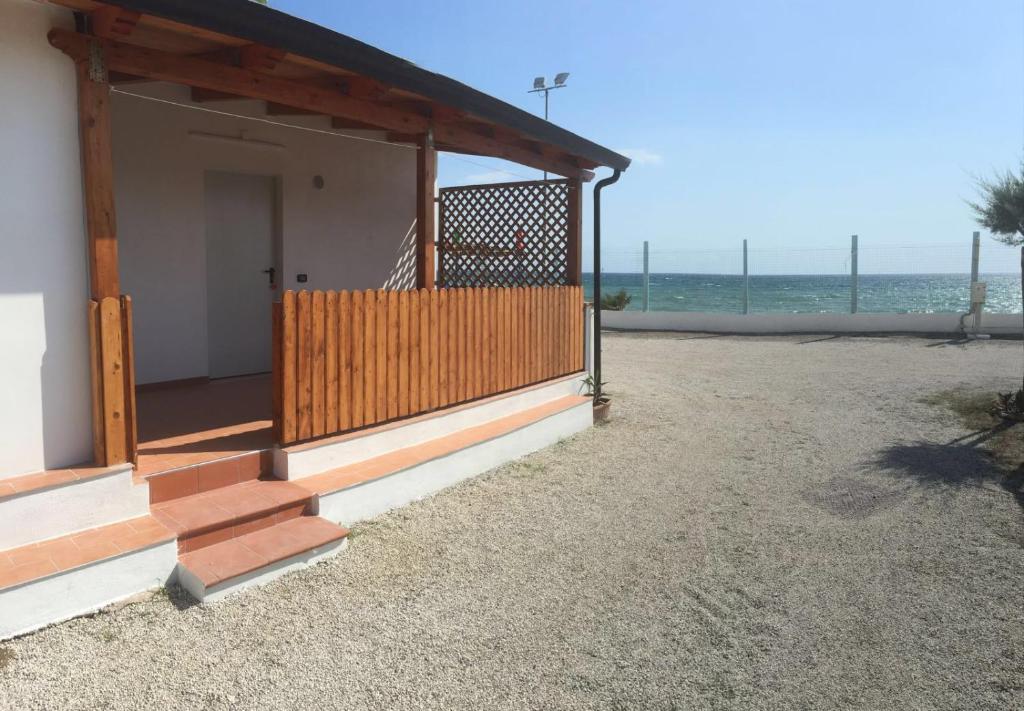 庞特卡格纳诺Camping Lido di Salerno的一座带门廊的建筑,以海洋为背景