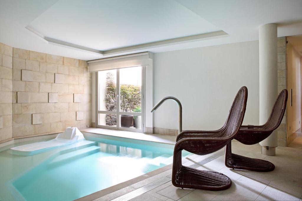 桑托托梅德尔普埃尔托Artesa Suites & Spa的一个带两把椅子的游泳池