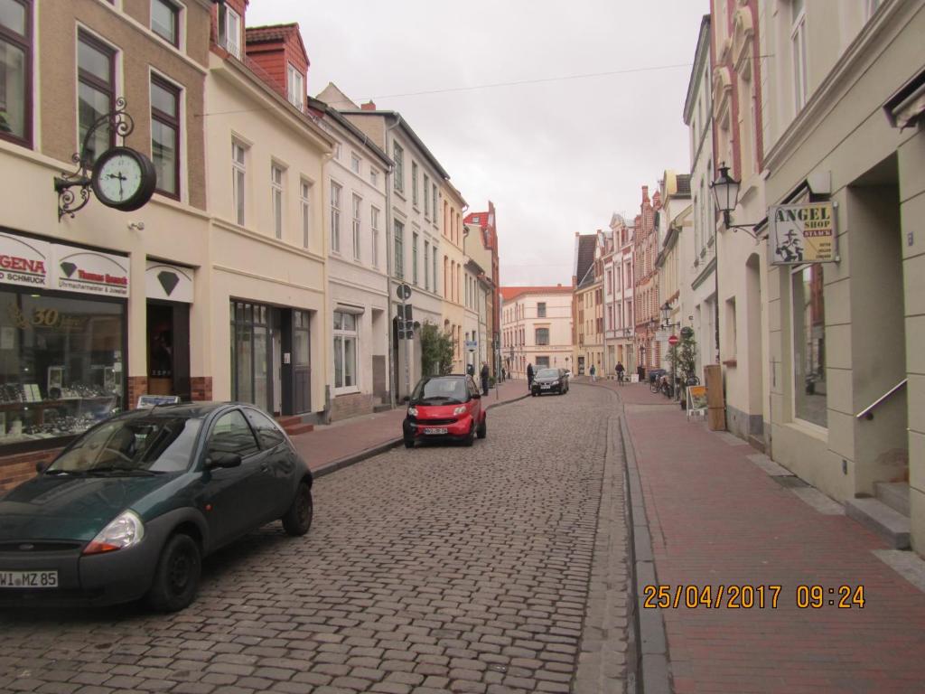 维斯马Altstadt Ferienwohnung的一条有汽车停在鹅卵石街道上的街道