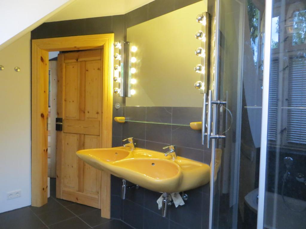 柏林Fischerhaus am See的浴室设有黄色水槽和镜子
