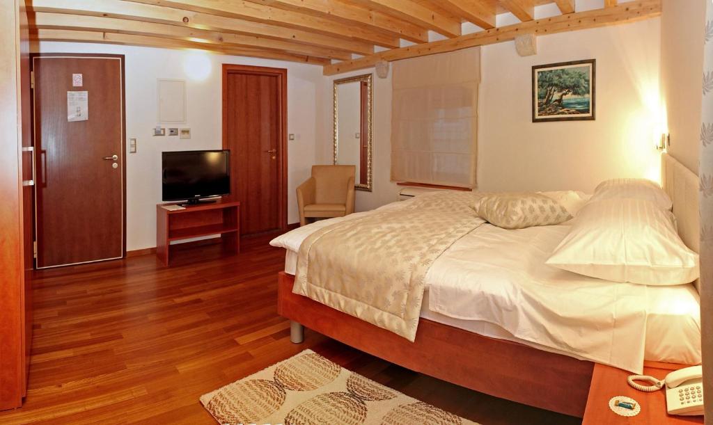 特罗吉尔莫妮卡酒店的一间卧室配有一张大床和电视