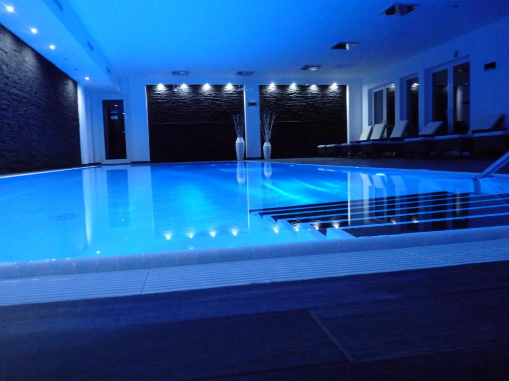 Neu ZaucheSpreewaldhof Romantik - Hotel Garni的蓝色灯光的建筑中的游泳池