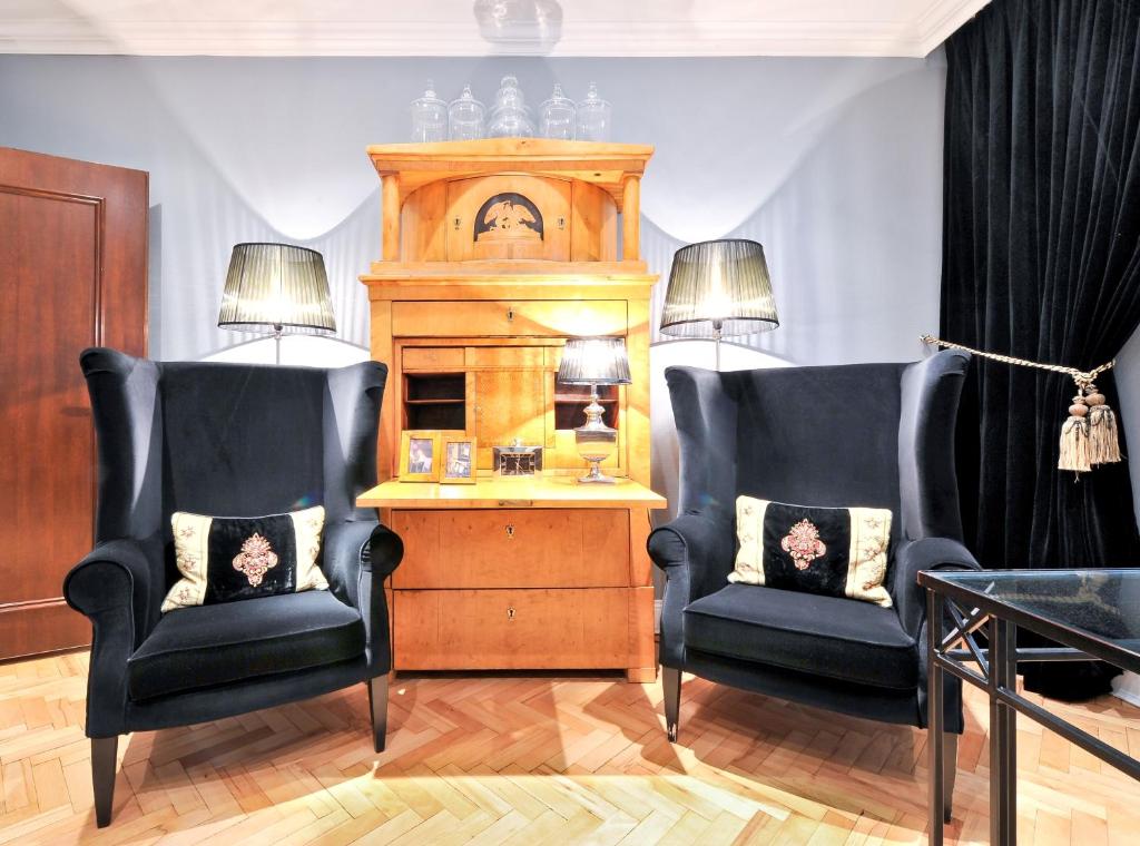 杜塞尔多夫奥斯塔先生与女士酒店的客厅配有两把椅子、桌子和时钟