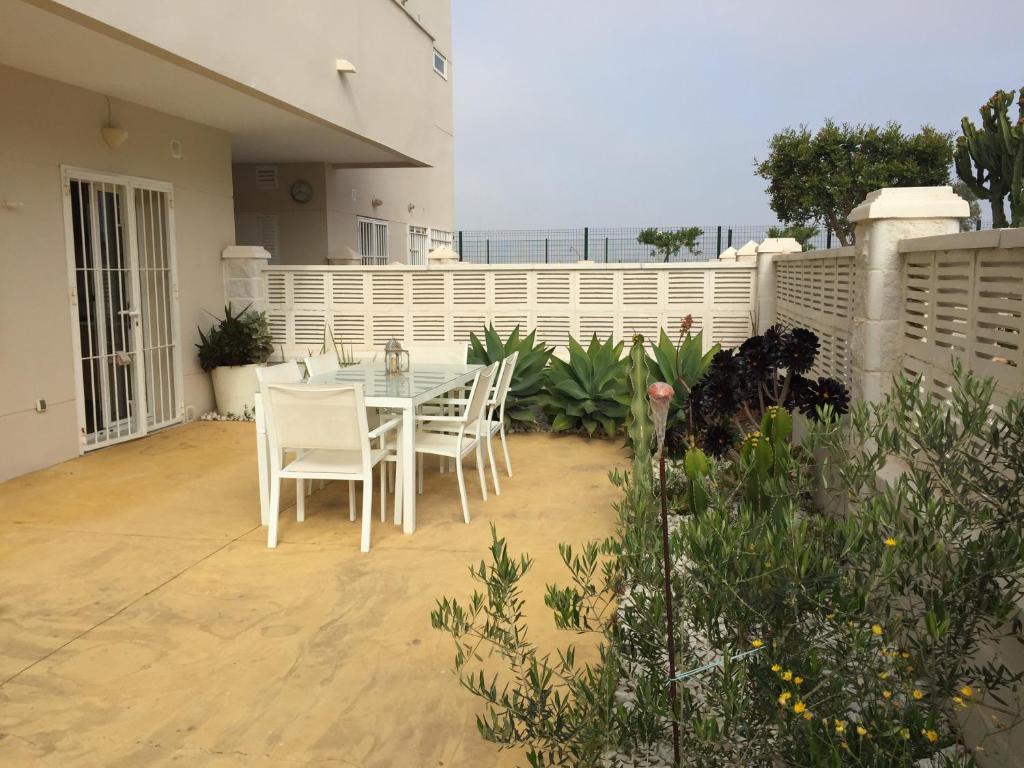 El ToyoCabo de Gata Oasis Retamar的一个带桌椅和围栏的庭院