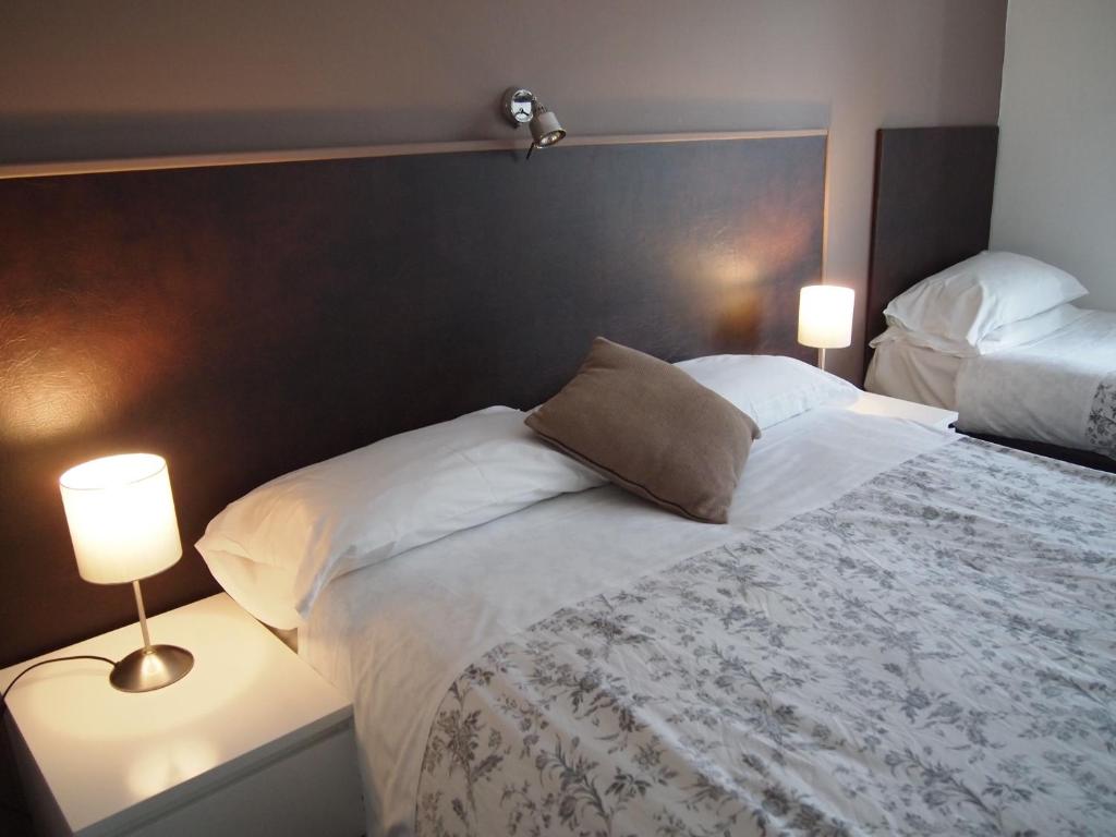 梅登黑德金斯伍德酒店的一间卧室配有一张大床和两盏灯