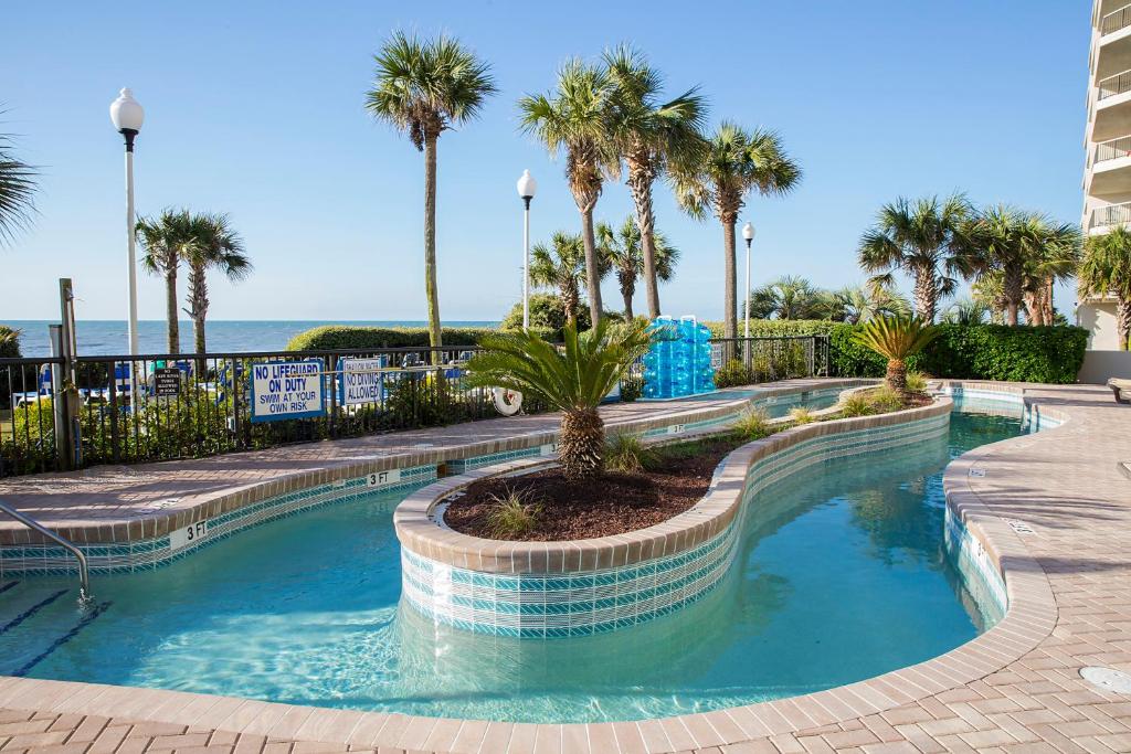 默特尔比奇格兰德舒尔斯酒店的一座棕榈树和海洋游泳池