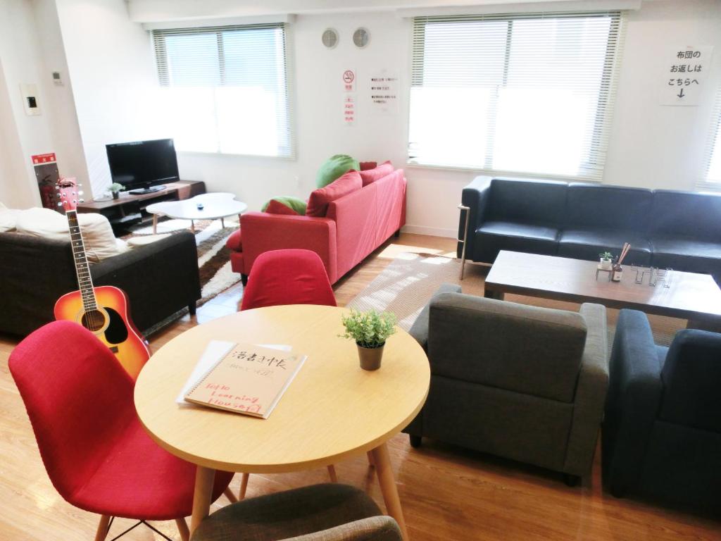 名古屋Guesthouse TOHO的一间设有桌椅和吉他的客厅