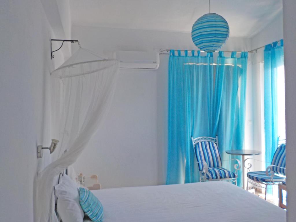 伊利索斯薇薇安一室公寓酒店的卧室配有白色的床和蓝色窗帘