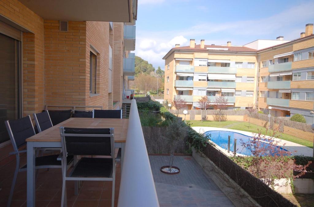 滨海托萨Lets Holidays Apartment Vinya del Pla的一个带桌椅的阳台和一个游泳池