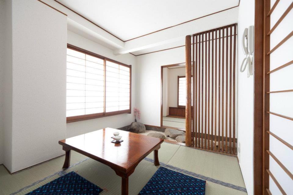 东京新大久保石亭酒店的一间带桌子的客厅和一间带狗的房间