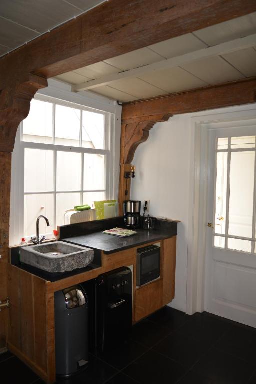 蒙尼肯丹Waterland Achterhuis的厨房设有水槽和窗户。