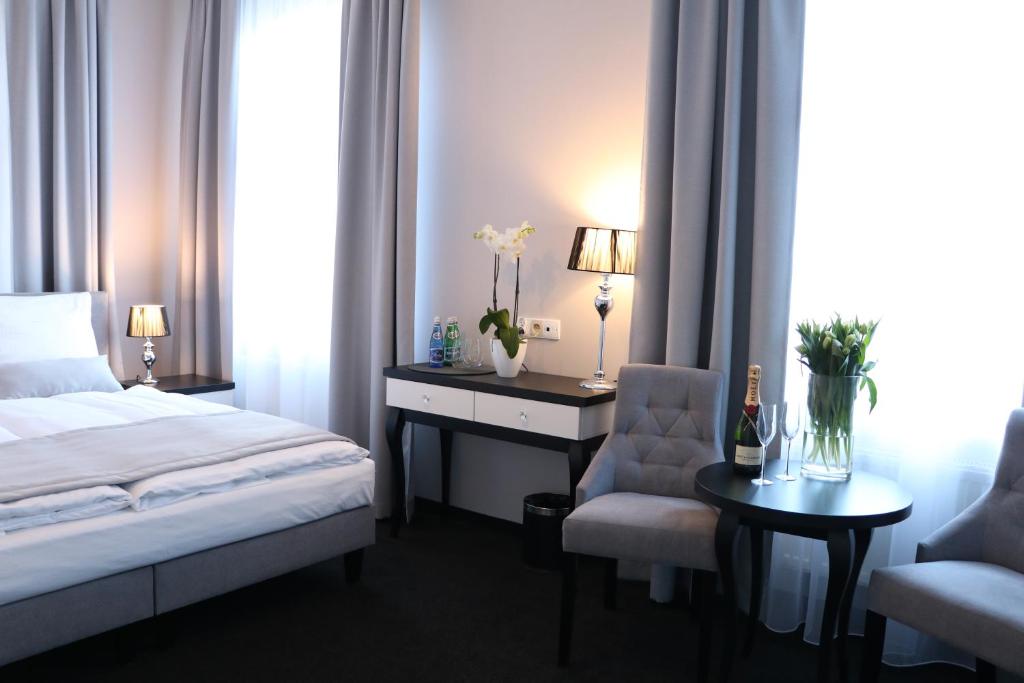 斯拉百斯卡西诺别墅酒店的一间卧室配有一张床、一张桌子和一把椅子