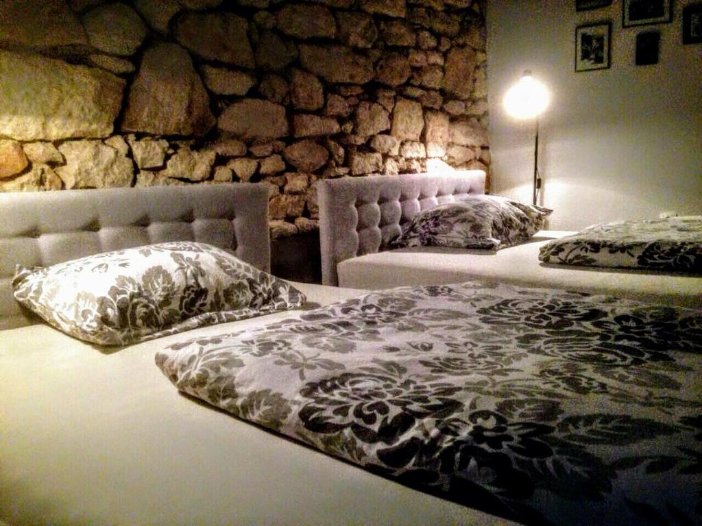 莫斯塔尔木萨拉旅舍的石墙客房的两张床