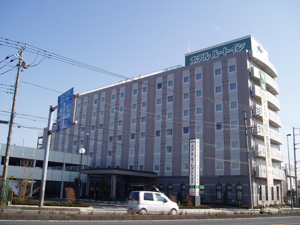 相模原市Hotel Route-Inn Sagamihara -Kokudo 129 Gou-的前面有一辆白色面包车的建筑