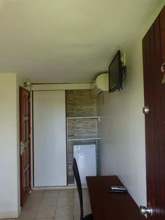 DucosAirport hotel的带冰箱的厨房和墙上的电视