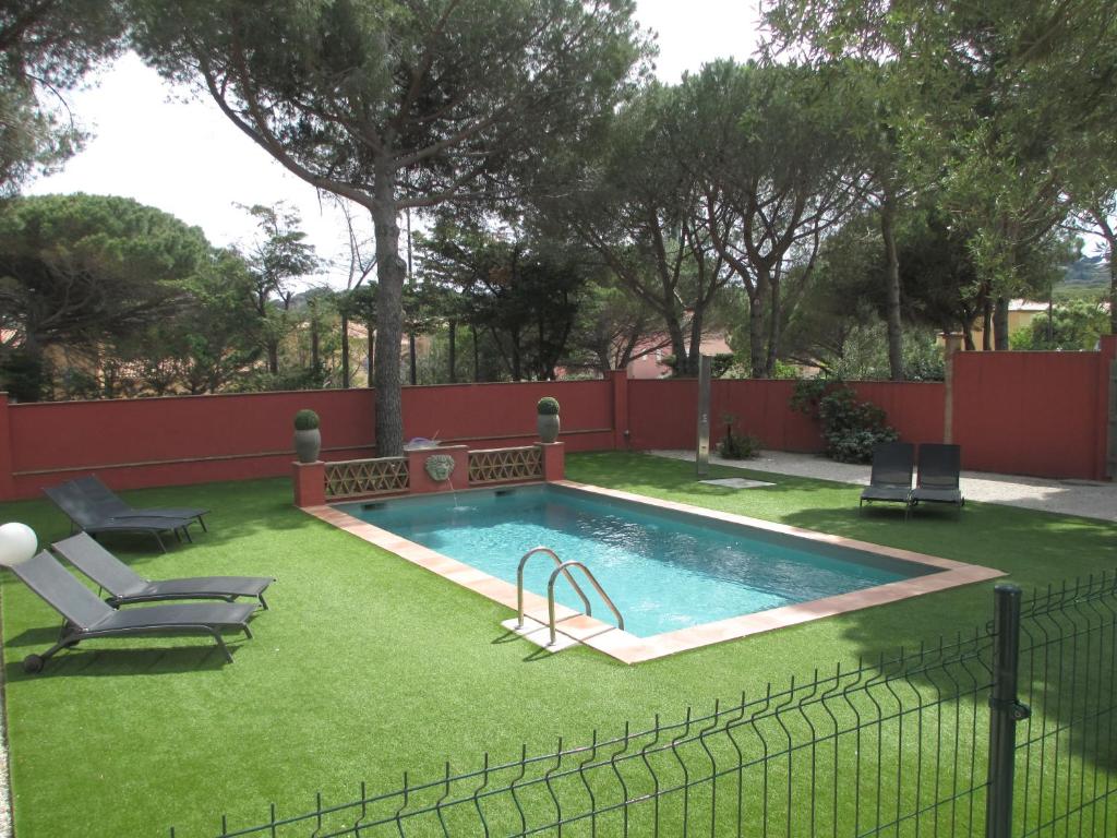 圣马克西姆蔚蓝达索特别墅酒店的围栏旁的绿色草地游泳池