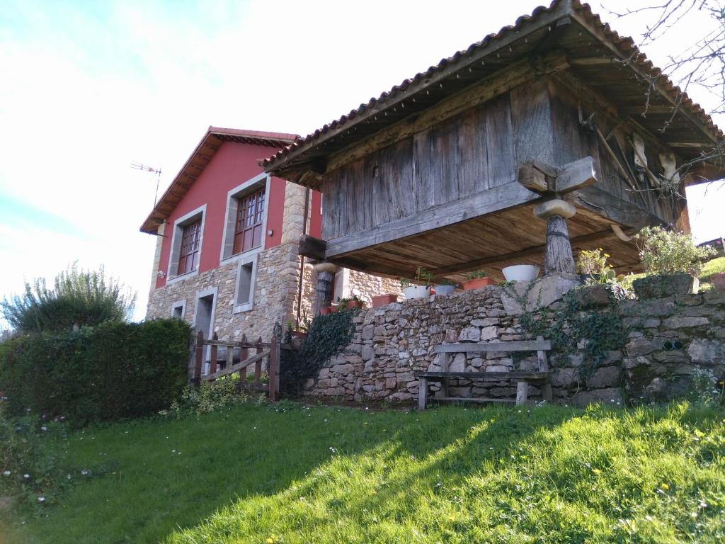 VillarmilCasa Rural La Cuesta的一座石墙和围栏的房子