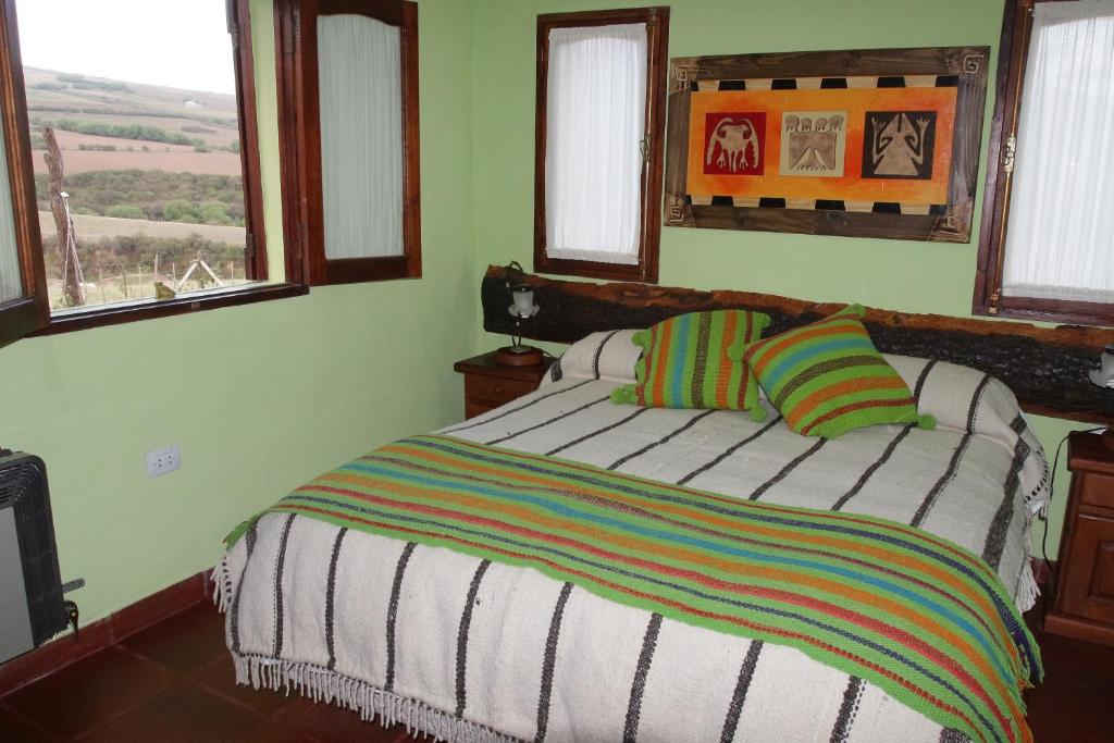 塔菲德尔瓦勒Villa Rural San Miguel de la Loma的一间卧室配有一张带条纹毯子的床和窗户。