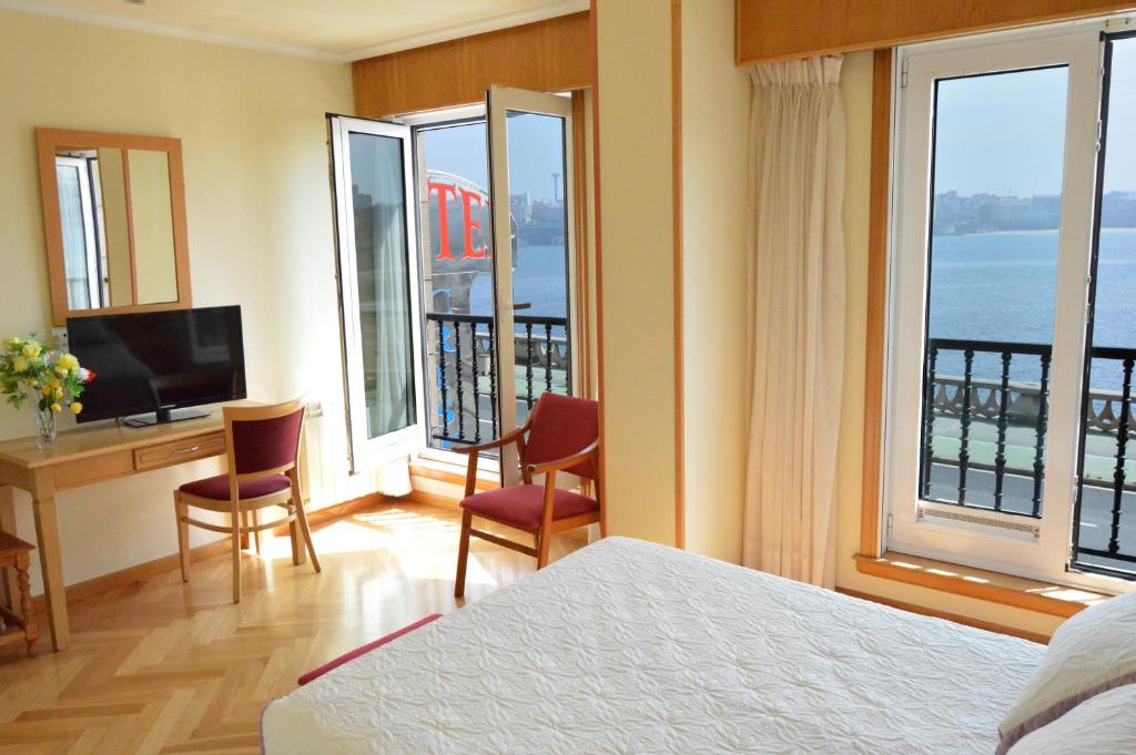 拉科鲁尼亚克瑞丝绦2号酒店的酒店客房设有一张床、一张书桌和窗户。