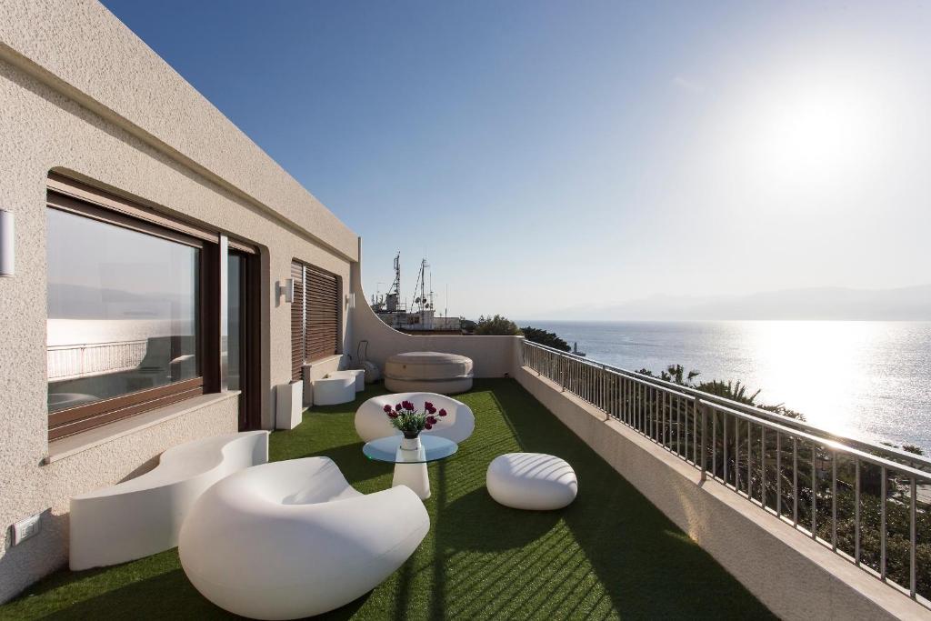 雷焦卡拉布里亚Reggio Suite的阳台配有白色椅子,享有海景。