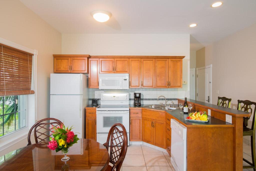 格雷斯湾皇家西印度群岛度假屋的厨房配有白色冰箱和桌椅