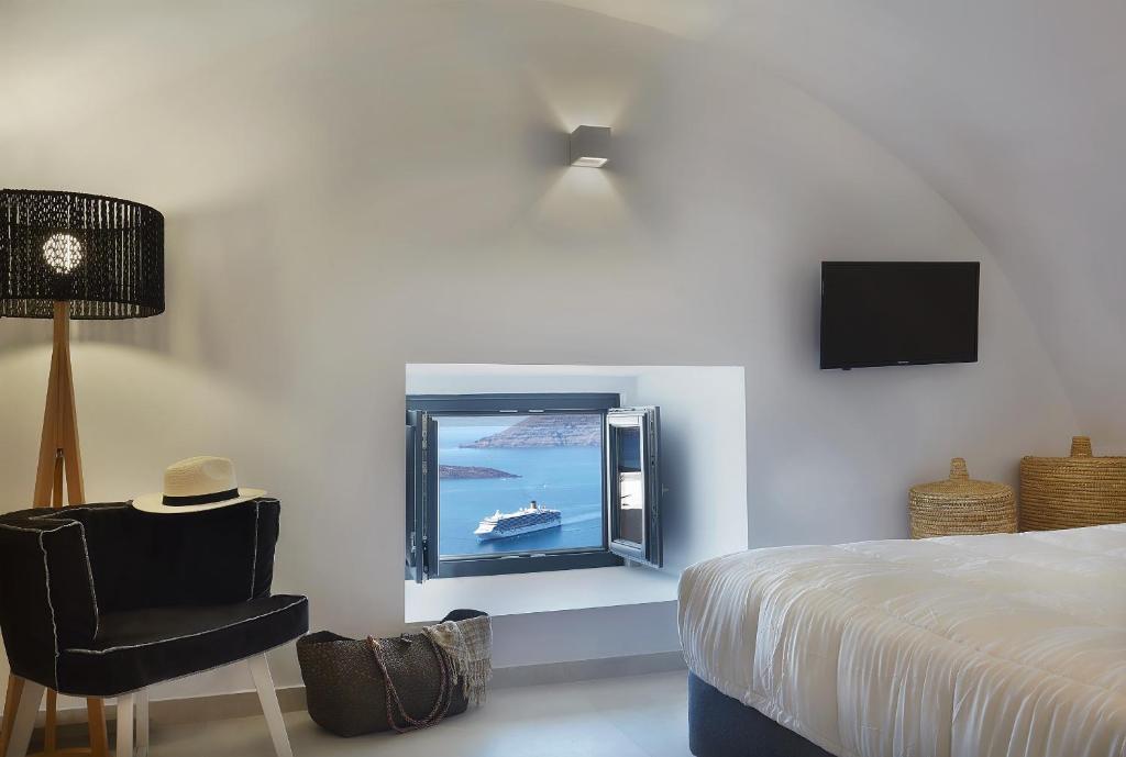 费拉卡利亚洞穴酒店 - 仅限成人的一间卧室配有一张床、一台电视和一把椅子