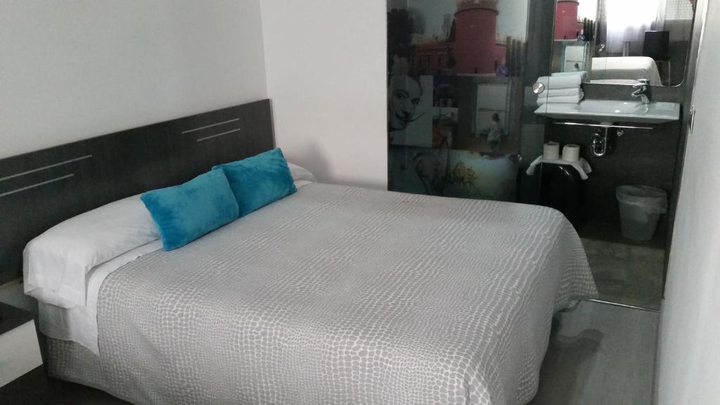 赫罗纳Bed&Breakfast 10 GIRONA的一间卧室配有一张带蓝色枕头的床