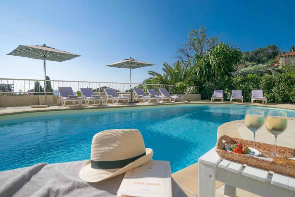 滨海自由城费南思比拉特酒店的游泳池旁的帽子和酒杯