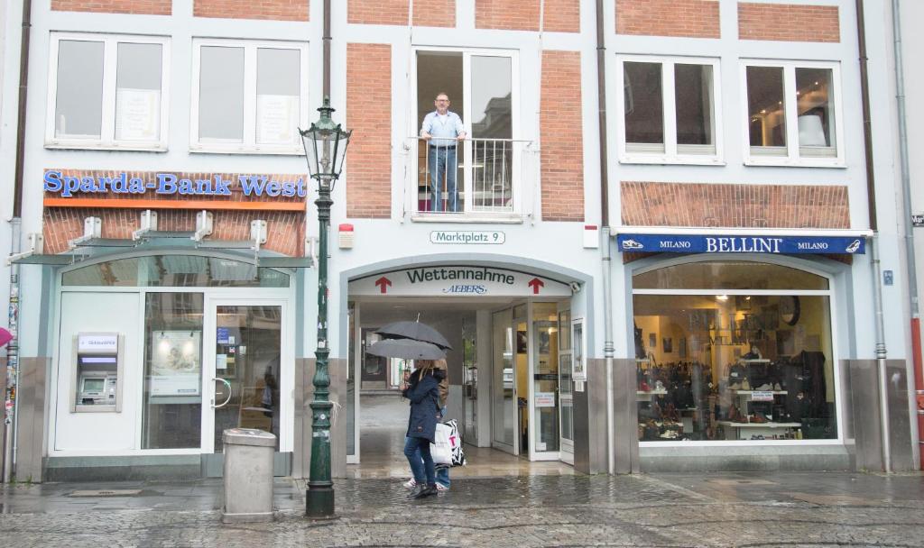 杜塞尔多夫Apartement mit Dachterrasse - bei Curth klingen - Teilen Sie uns Ihre Ankunfszeit mit的一位带着雨伞沿着街道走的女人