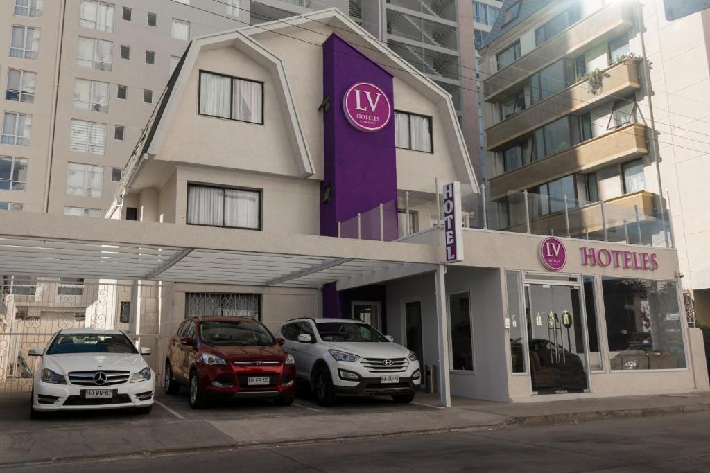 维纳德马LV Hoteles Boutique的停在酒店门前的两辆汽车