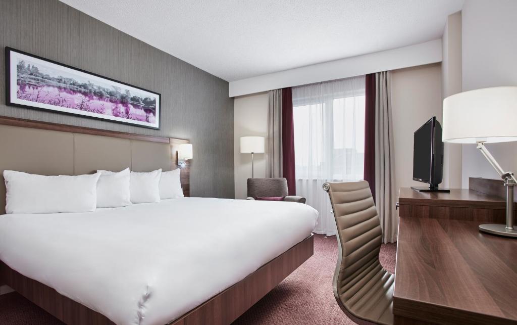 德比Leonardo Hotel Derby的酒店客房设有一张大床和一台电视机。