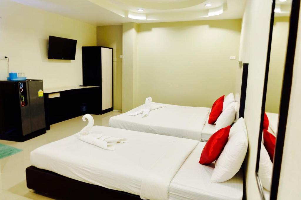 乌汶百特普雷斯酒店的一间卧室配有两张带红白色枕头的床