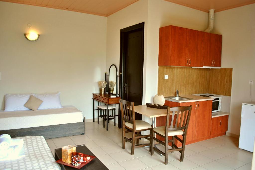 米提卡斯Iliovasilema Hotel的一间带一张床的房间和一间带桌子的厨房