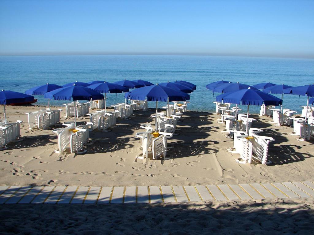 切萨雷奥港Villa Nausica的海滩上的一组椅子和遮阳伞