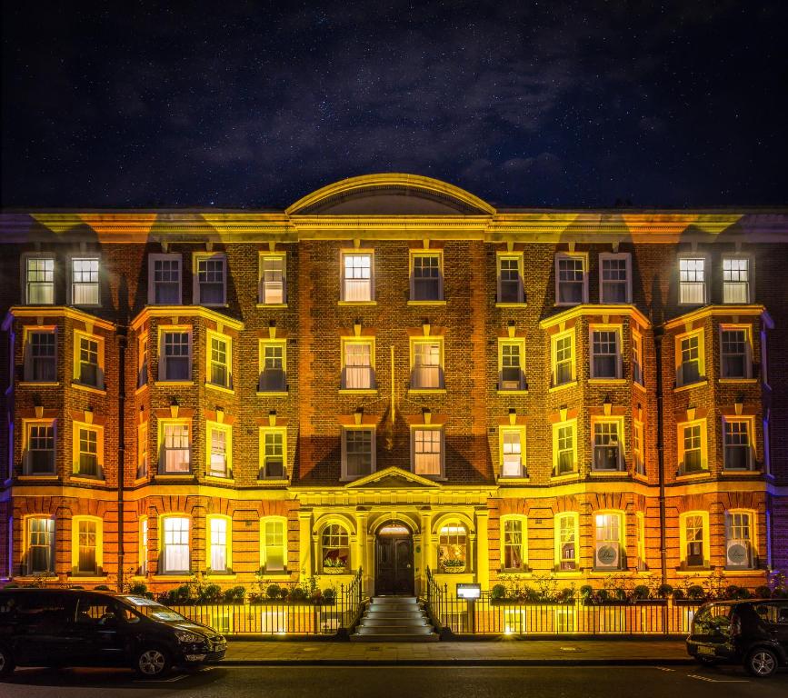 伦敦曼彻斯特街十酒店的一座大型砖砌建筑,晚上有灯