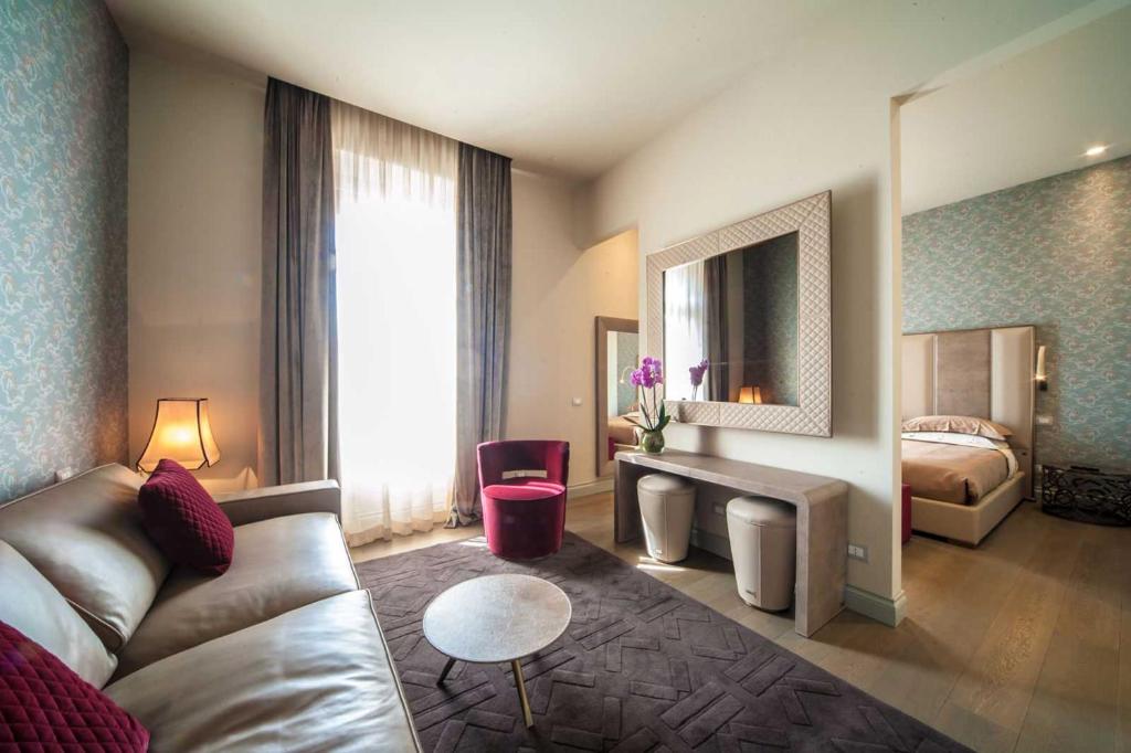 罗马维托里亚诺奢华套房旅馆的酒店客房设有一张沙发和一张床