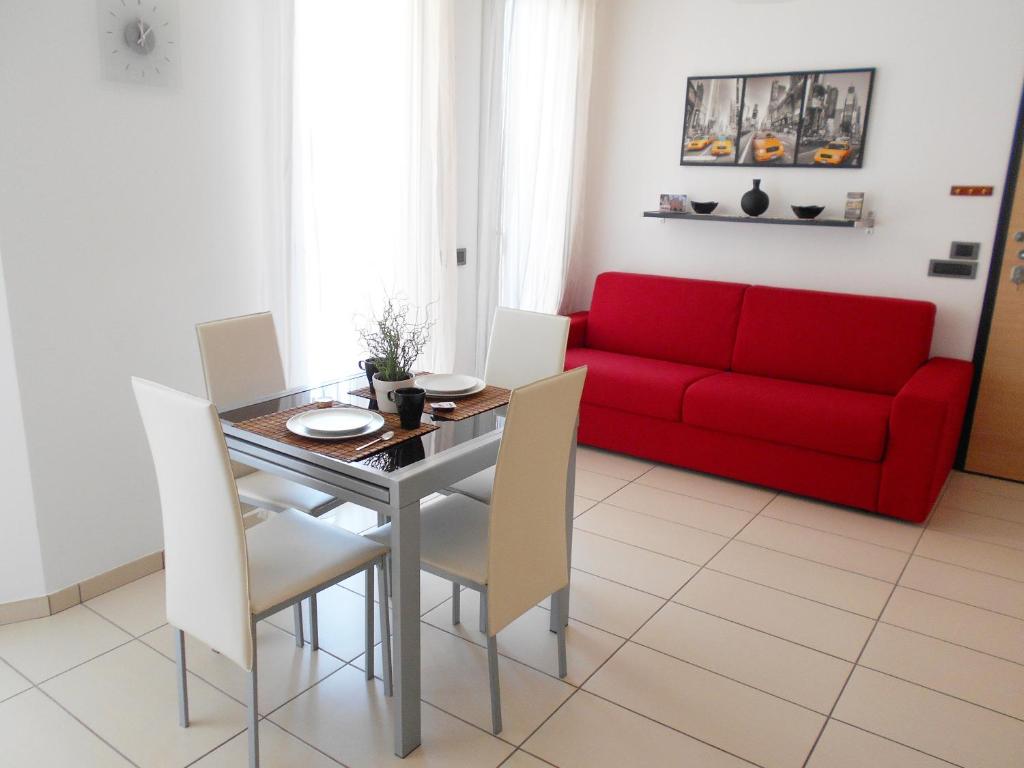 阿尔巴La trifula bianca apts.的客厅配有红色的沙发、桌子和椅子