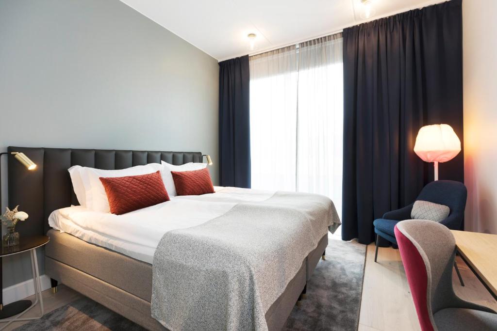 乌普萨拉学院精英酒店的酒店客房带一张大床和一把椅子