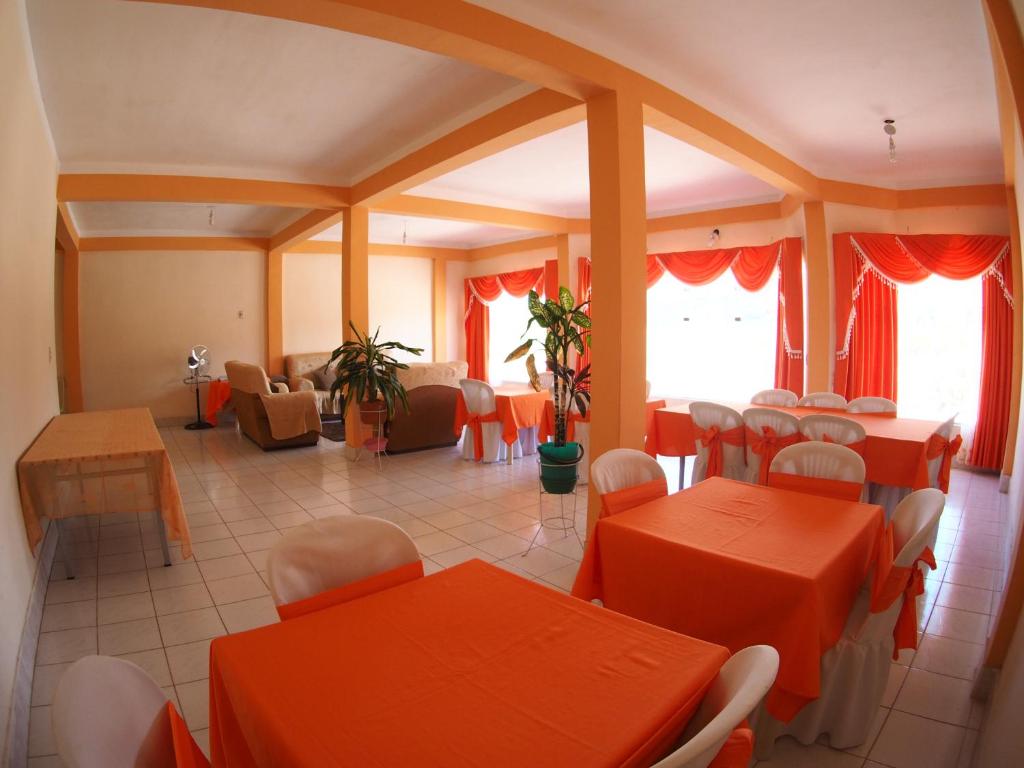 图皮萨Hostal Butch Cassidy的用餐室配有橙色桌椅