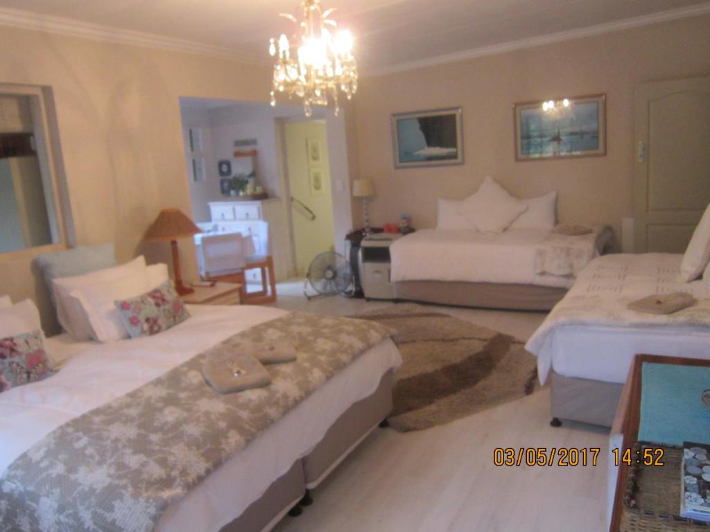 普利登堡湾暮光小屋旅馆的一间卧室配有两张床和吊灯。