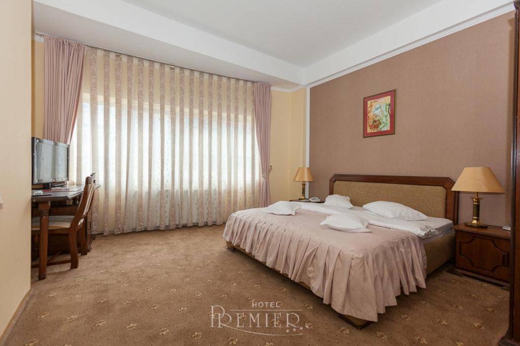 克卢日-纳波卡尊贵酒店的配有一张床、一张书桌和一扇窗户的酒店客房