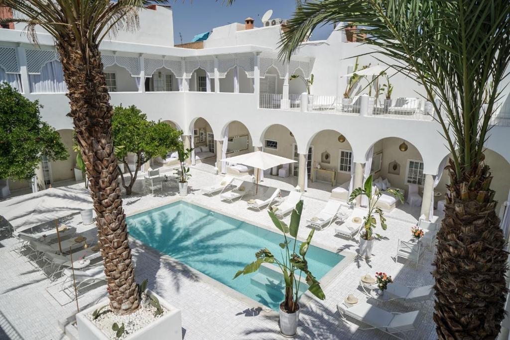马拉喀什Riad Palais Blanc & Spa的棕榈树酒店和游泳池的图片