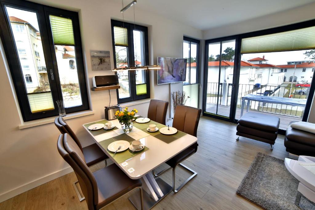 巴贝Ferienwohnung "Lachmöwe" Baabe的一间带桌椅和窗户的用餐室