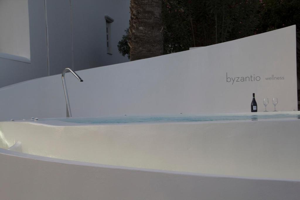 艾西奥斯索蒂斯Byzantio Beach Suites & Wellness的客房内的浴缸,提供一瓶葡萄酒