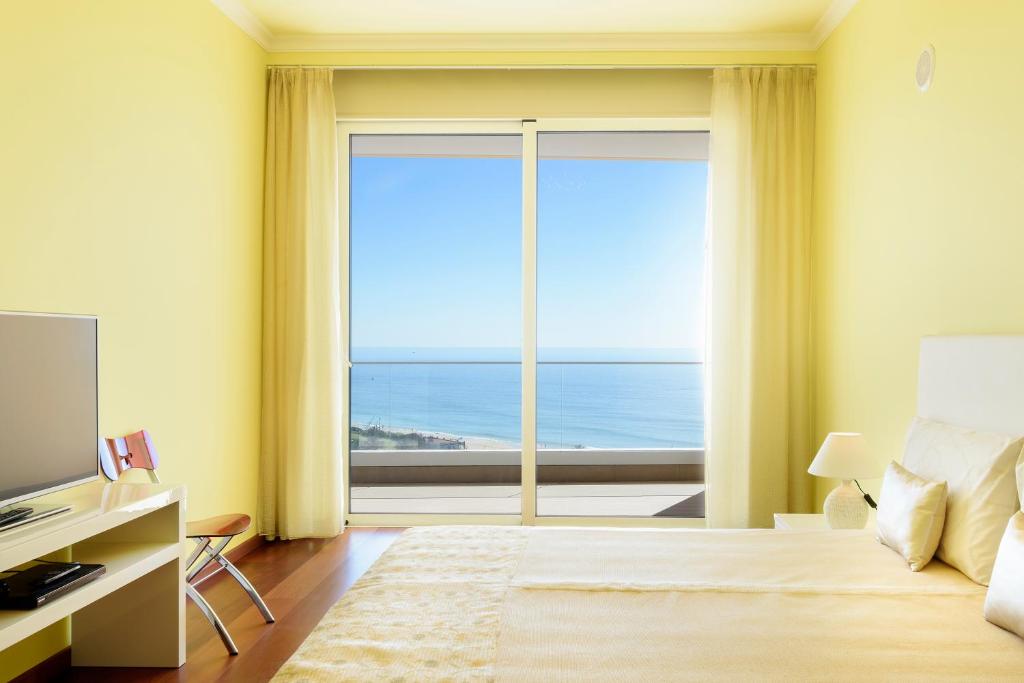 拉戈斯Porto de Mos Golf & Beach B&B AL-40312的卧室设有海景大窗户
