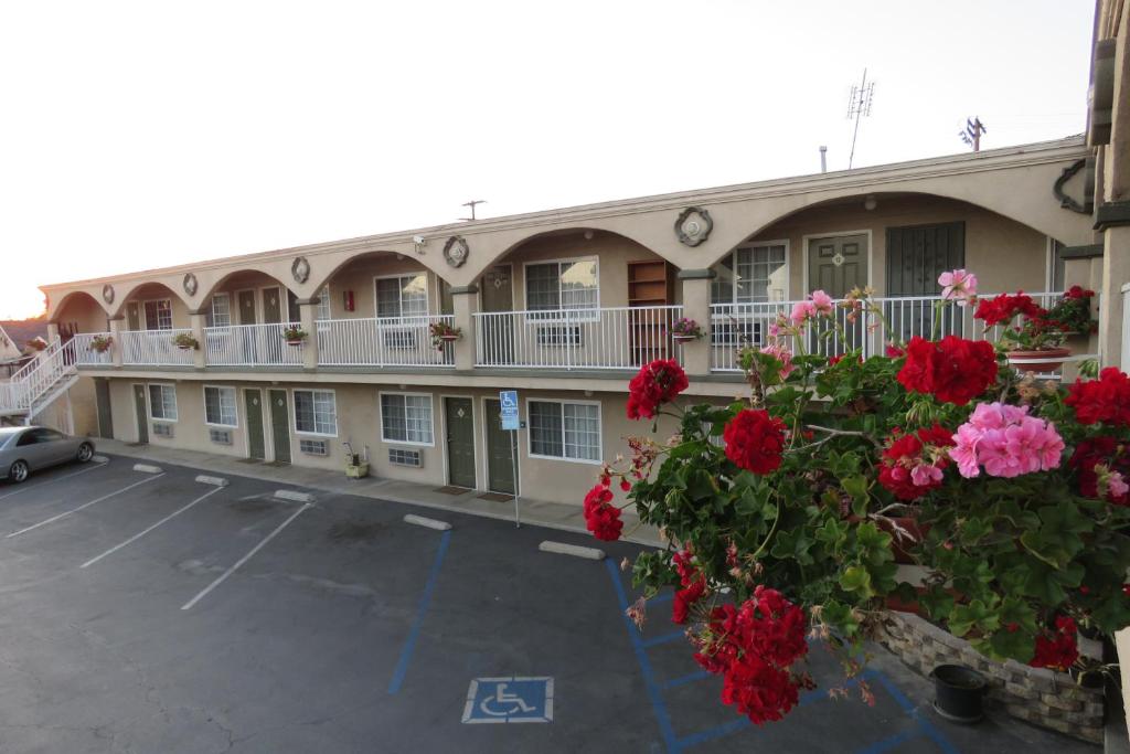 洛杉矶Florentina Motel - Los Angeles的在停车场里开满红花的酒店
