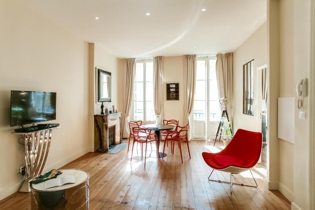 波尔多YBH大教堂公寓的客厅配有红色椅子和桌子