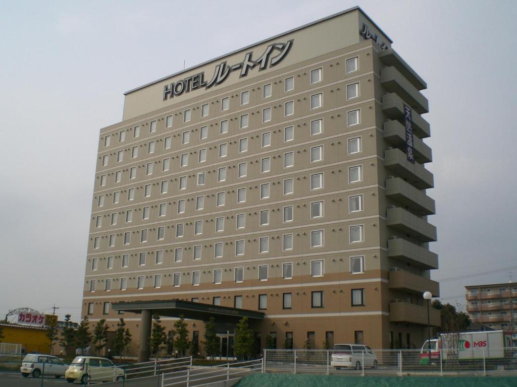 大洲Hotel Route-Inn Aso Kumamoto Airport Ekimae的一座酒店大楼,上面有标志