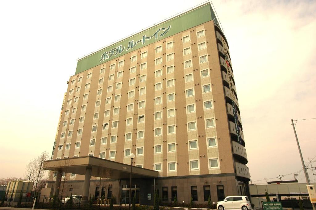 弘前市弘前城东路线酒店的一座酒店大楼,前面有停车位