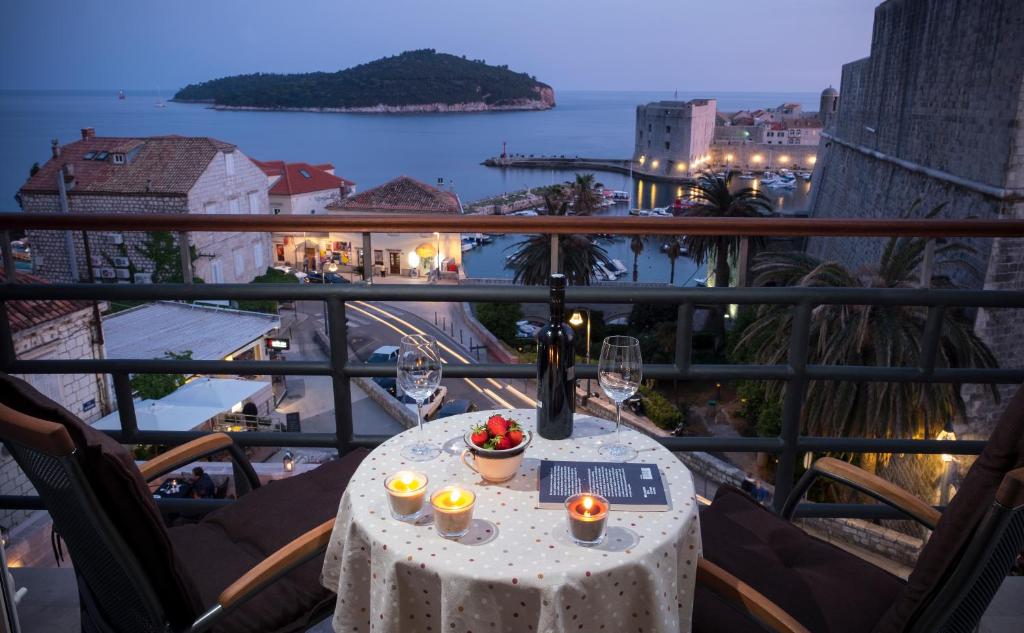 杜布罗夫尼克Ragusina luxury apartments的阳台上的桌子上摆放着酒杯和蜡烛